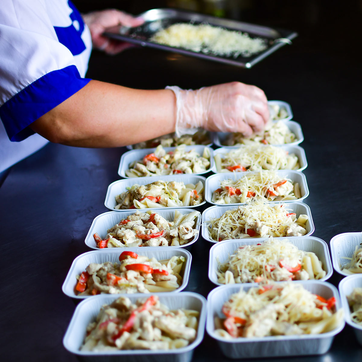 Une personne prépare des plats prêts à être congelés pour les popotes